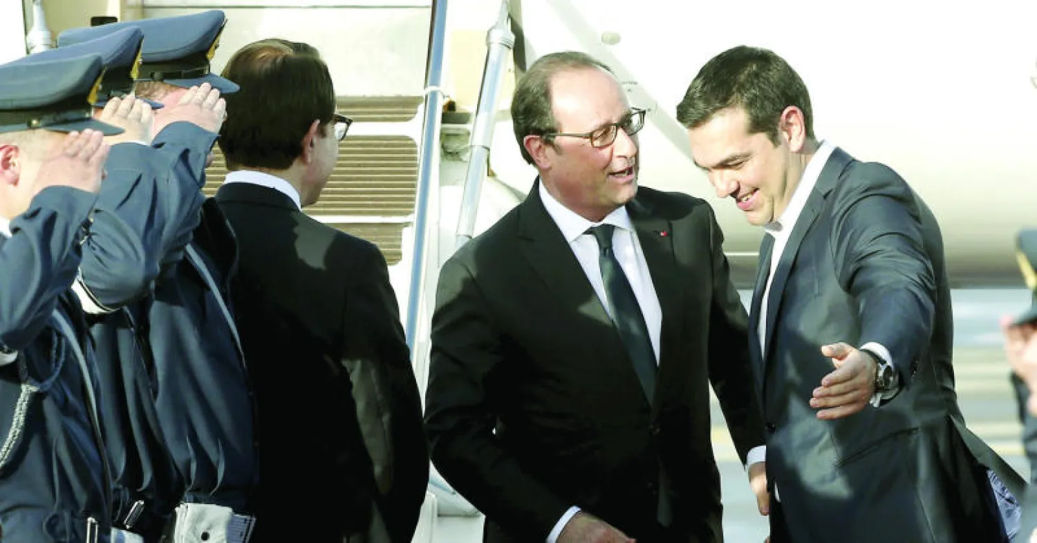 ألكسيس تسيبراس مستقبلاً هولاند في أثينا أمس (رويترز)