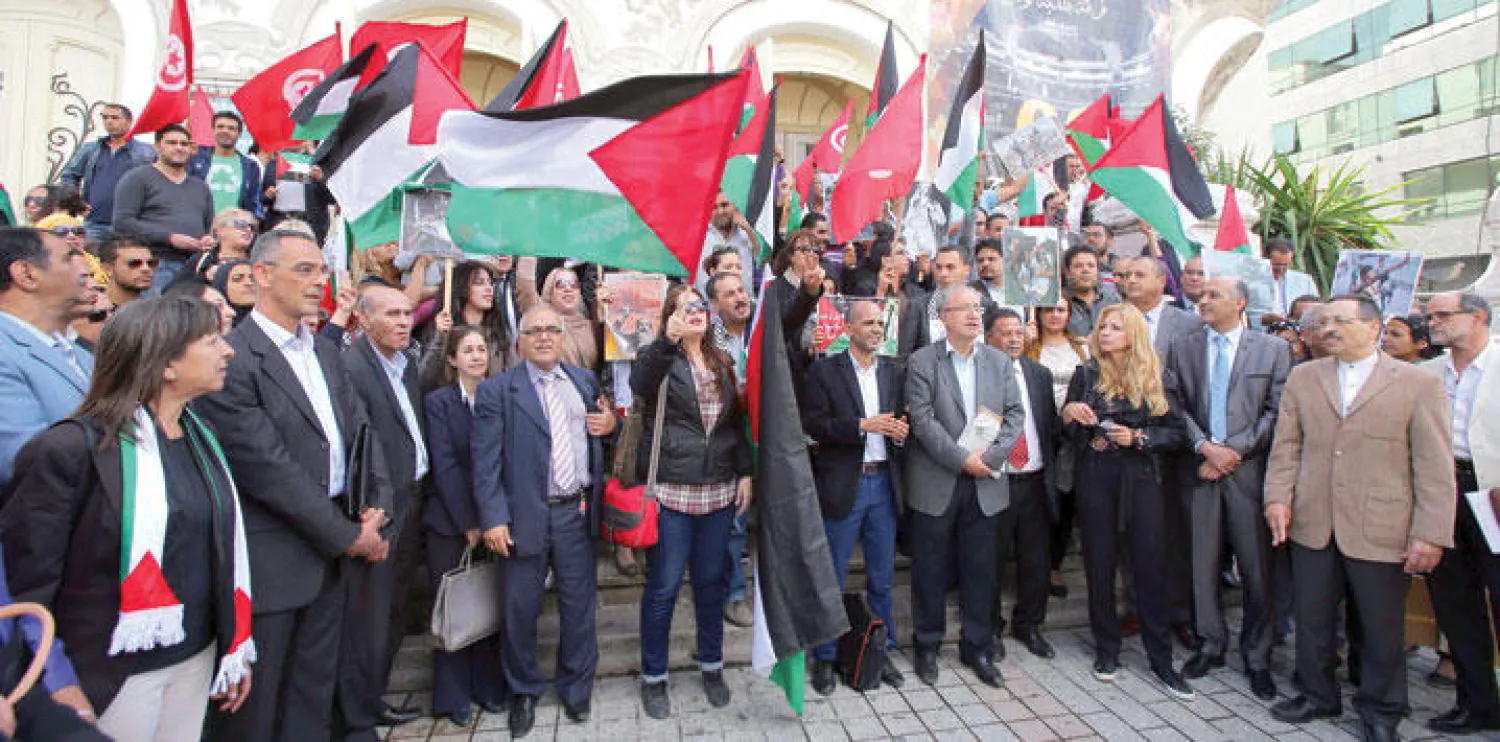 تونسيون يشاركون في مسيرة نظمت أمس بشوارع تونس العاصمة للتنديد بالعدوان الإسرائيلي على الفلسطينيين (إ.ب.أ)