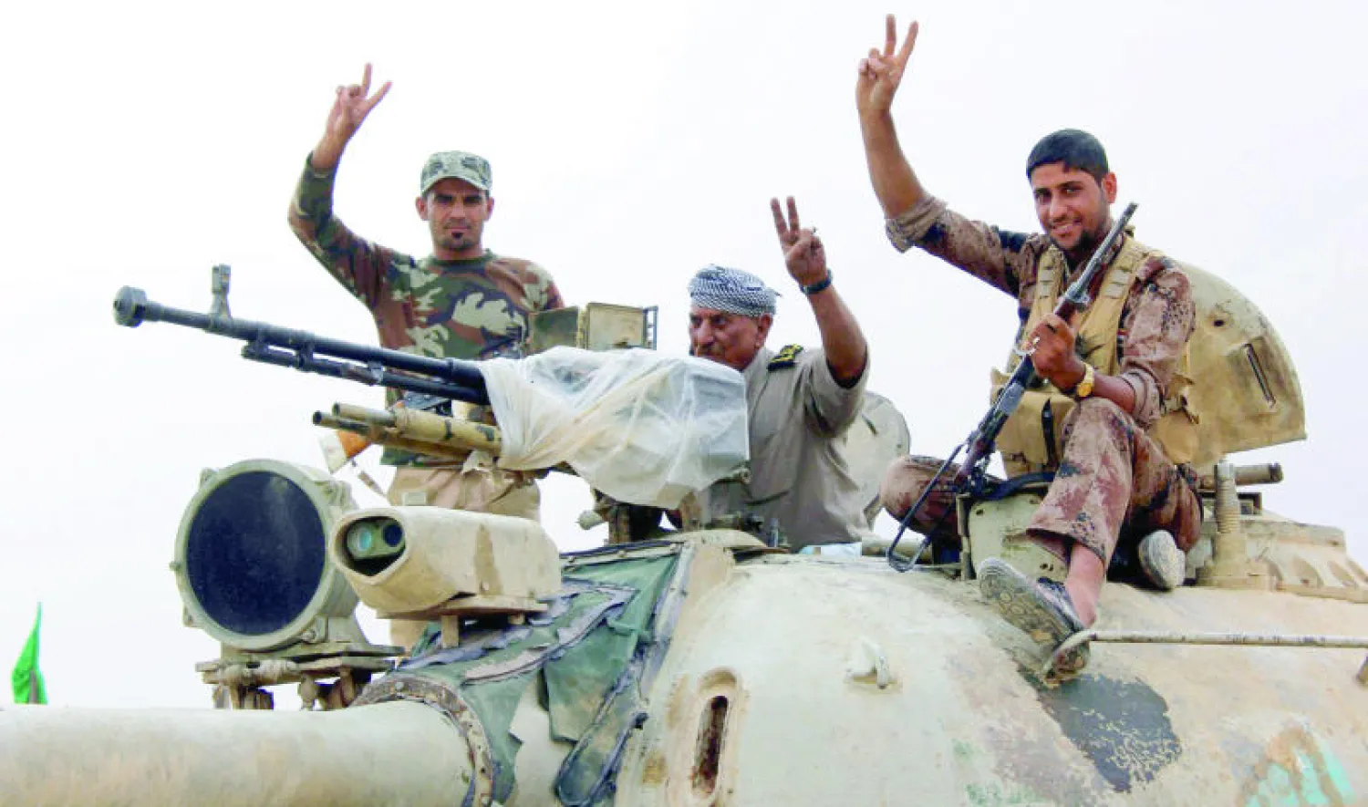 مقاتلون عراقيون يتوجهون فوق دبابتهم إلى جبهة كركوك لقتال مسلحي «داعش» أمس (إ.ب.أ)