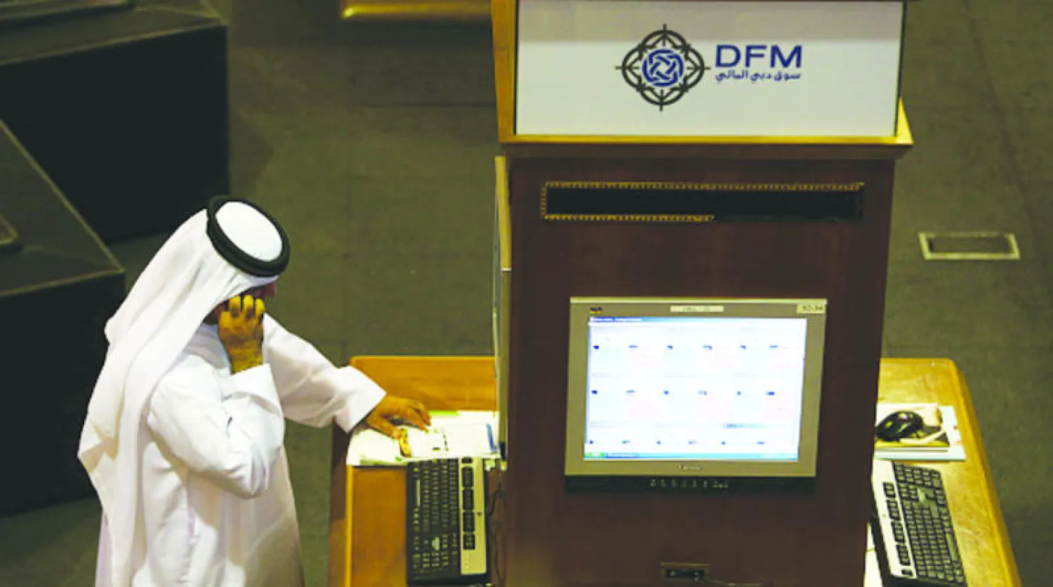 متعامل في سوق دبي المالي يتابع مؤشرات البورصة (غيتي)