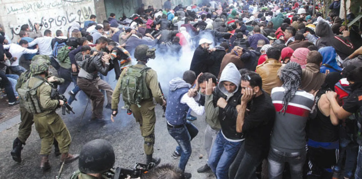 قوات الاحتلال الإسرائيلي تطلق قنابل مسيلة للدموع لتفريق متظاهرين اشتبكوا مع أفرادها في مدينة الخليل (أ.ف.ب)