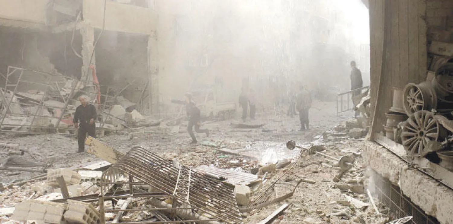 سكان بلدة عين ترما بريف دمشق يتفحصون الأضرار التي لحقت بمنطقتهم بعد قصف الطيران الحربي لها أمس (غيتي)