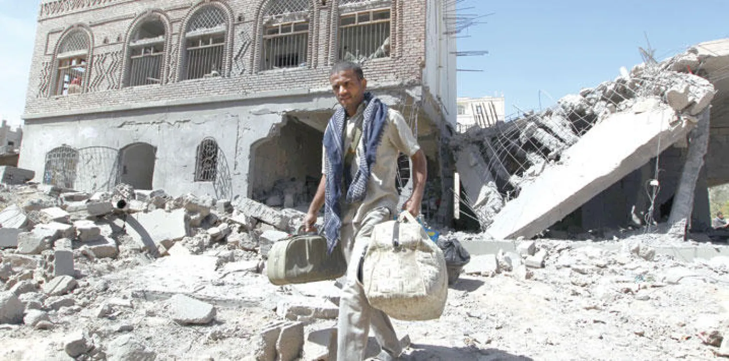 يمني يسير بين حطام أبنية تعرضت للدمار بسبب المعارك بين قوات التحالف وقوات الحوثيين أمس ({غيتي})