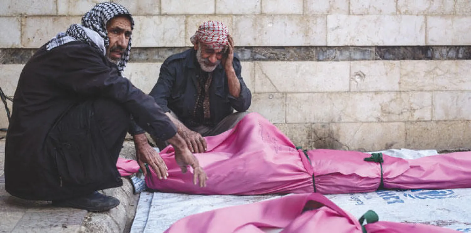 رجلان من سكان بلدة دوما بريف دمشق الشرقي يبكيان ضحاياهما بعد غارة للطيران الحربي أمس تسببت بمقتل 15 شخصا (إ.ب.أ)