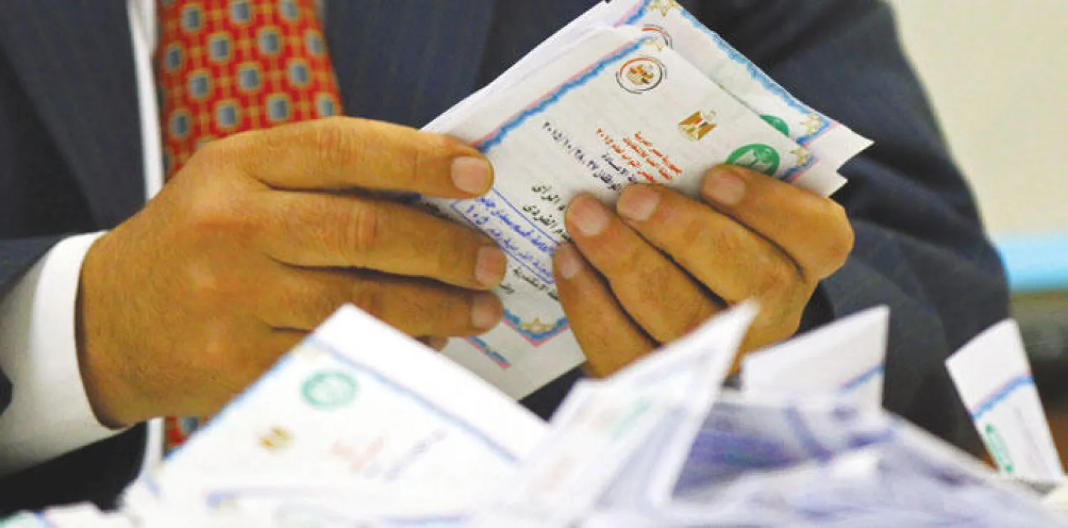 موظف في اللجنة الانتخابية يفرز الأصوات في مركز اقتراع بمدينة الإسكندرية (إ.ب.أ)