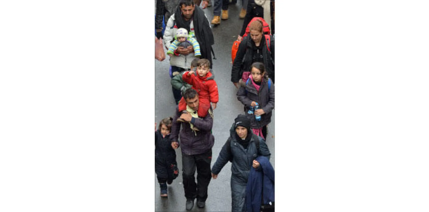 طابور من عائلات المهاجرين بعد عبور الحدود النمساوية باتجاه ألمانيا.. وينتظر آلاف من اللاجئين في دول البلقان أيامًا طويلة بانتظار السماح لهم بالعبور إلى دول أوروبا الغربية (أ.ب)