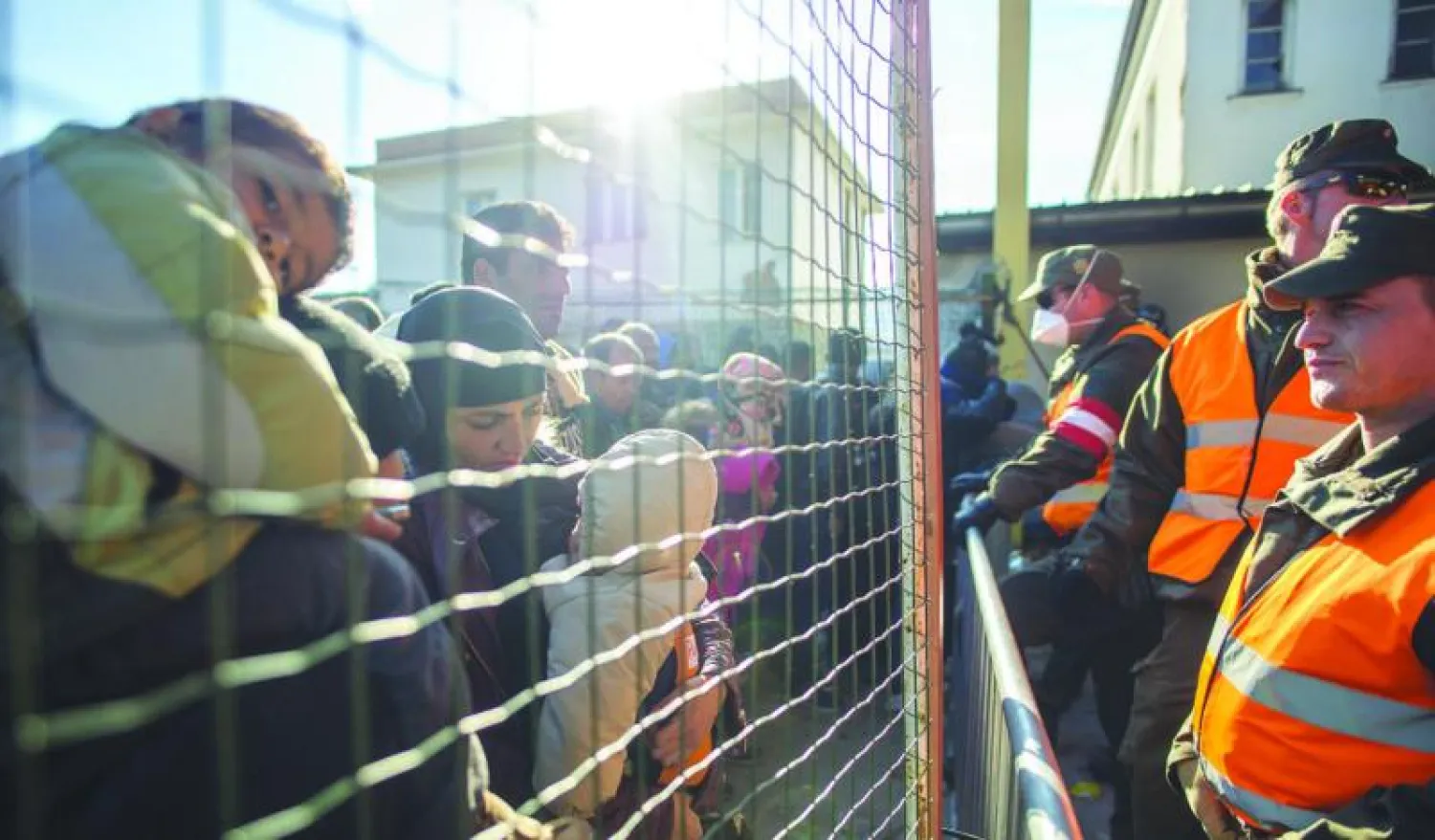 لاجئون في انتظار عبور الحدود والأسلاك الشائكة من منطقة العبور  سنتيغلي في سلوفينيا باتجاه النمسا أمس (أ.ف.ب)