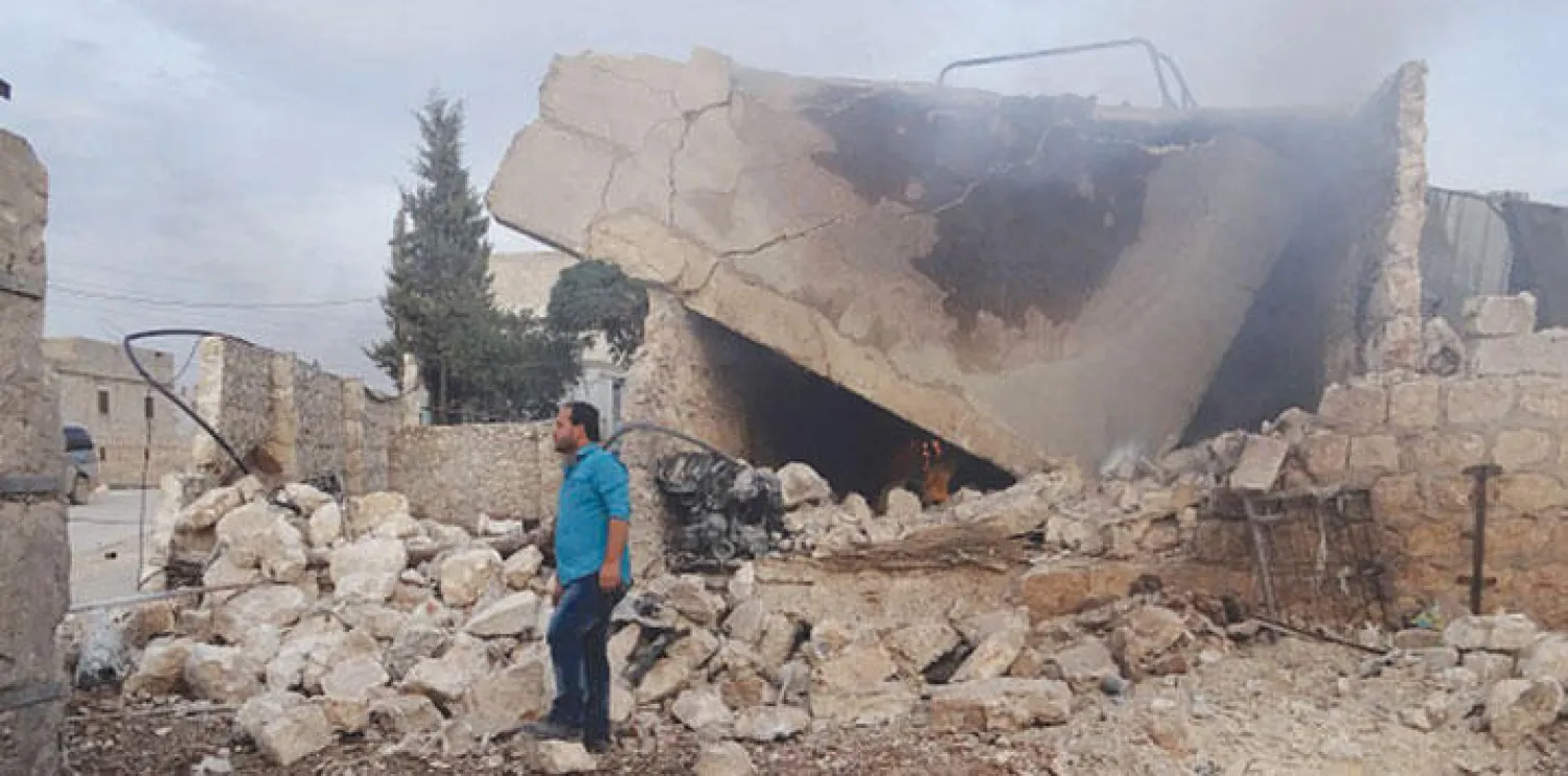 سوري يقف بالقرب من أنقاض مبنى مهدم بفعل الغارات الروسية أمس على مدينة خان طوقان جنوب حلب ({غيتي})