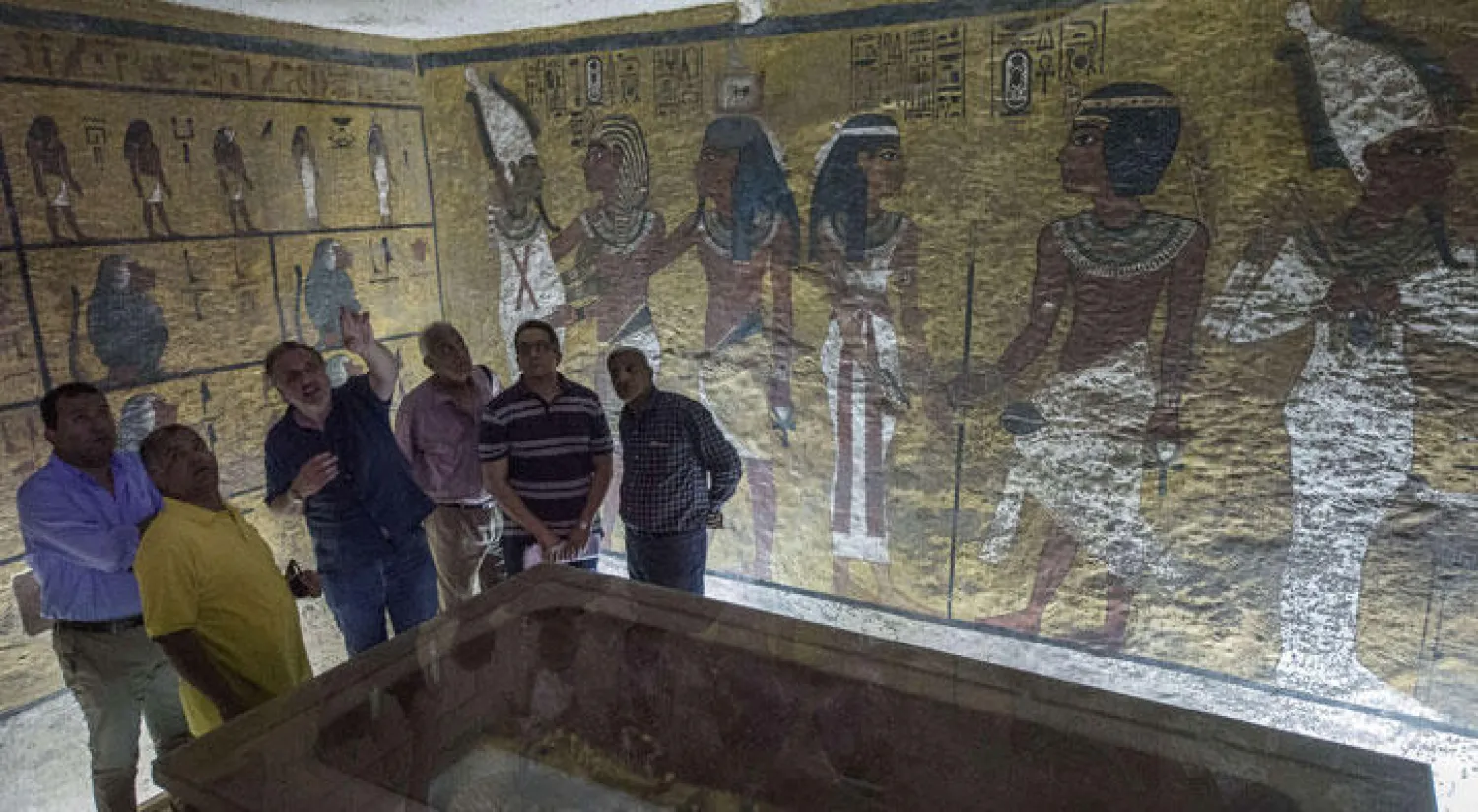 وزير الآثار المصري ممدوح الدماطي والعالم الإنجليزي نيكولاس ريفز ومسؤولون آخرون يعاينون تابوت الملك توت عنخ آمون في غرفة دفنه في وادي الملوك بالقرب من الأقصر (أ.ف.ب)
