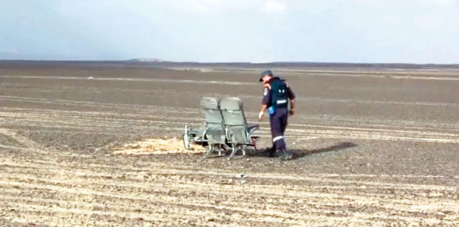 صورة وزعتها وزارة الطوارئ الروسية أمس لأحد محققيها وهو يعاين مقعدين من الطائرة الروسية التي سقطت في سيناء السبت الماضي (أ.ب)