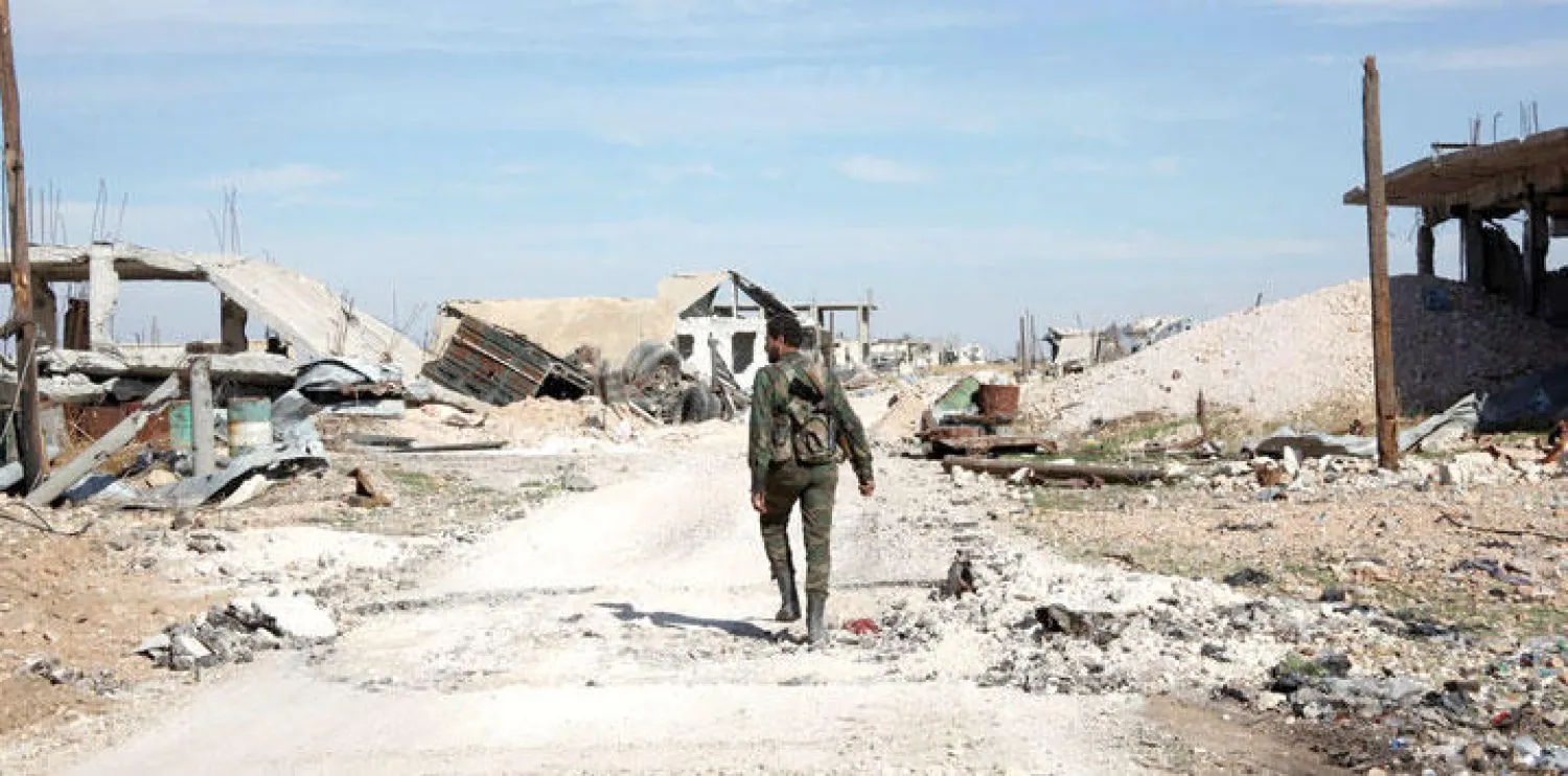 جندي من قوات النظام السوري على الطريق في إحدى القرى المتاخمة لمطار كويرس العسكري في محافظة حلب بشمال سوريا (أ.ف.ب)