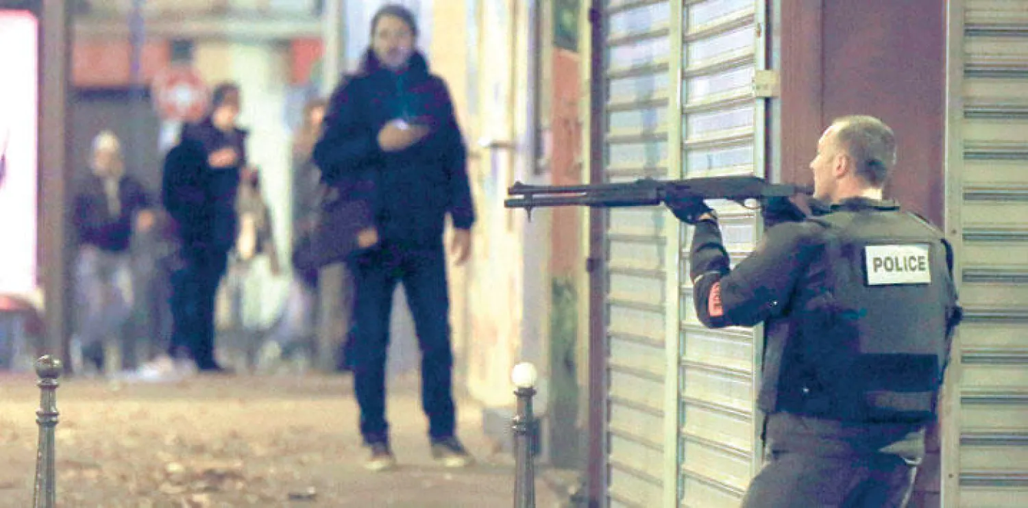 شرطي فرنسي يحمل سلاحه بالقرب من المطعم الباريسي الذي قتلت فيه الشقيقتان التونسيتان ليلة أول من أمس (إ.ب.أ)