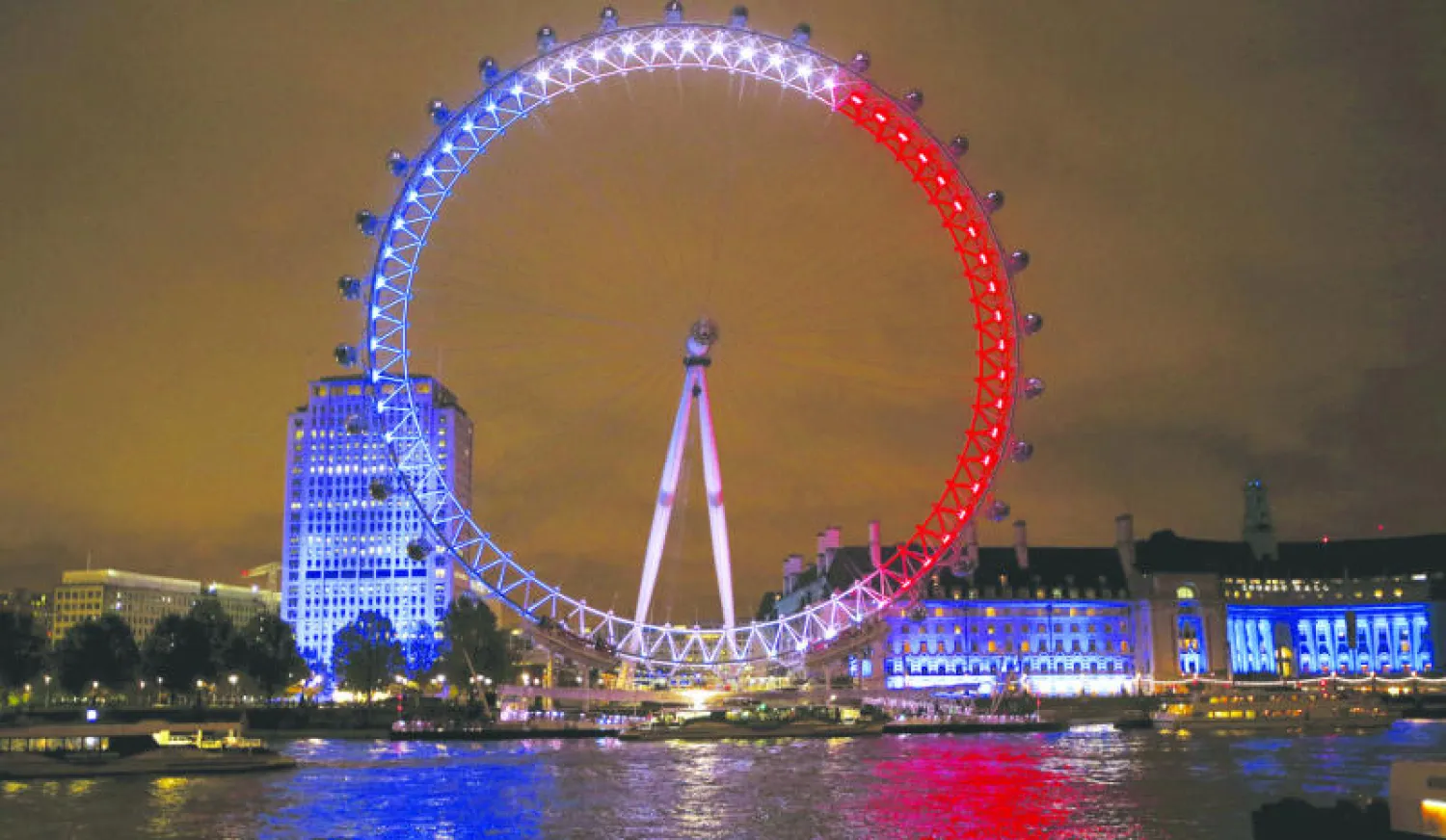 ألوان العلم الفرنسي الأحمر والأبيض والأزرق تضوي في لندن للتضامن مع فرنسا (رويترز)