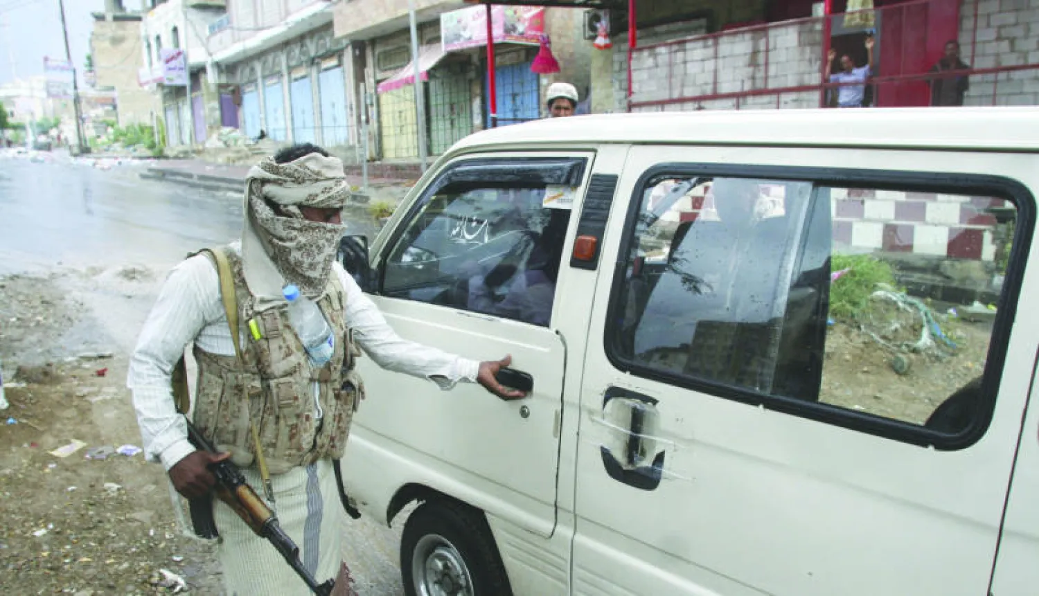 عناصر من المقاومة الشعبية الموالية للحكومة الشرعية تتفقد سيارة عند نقطة تفتيش في تعز ثالث أكبر المدن اليمنية (رويترز)