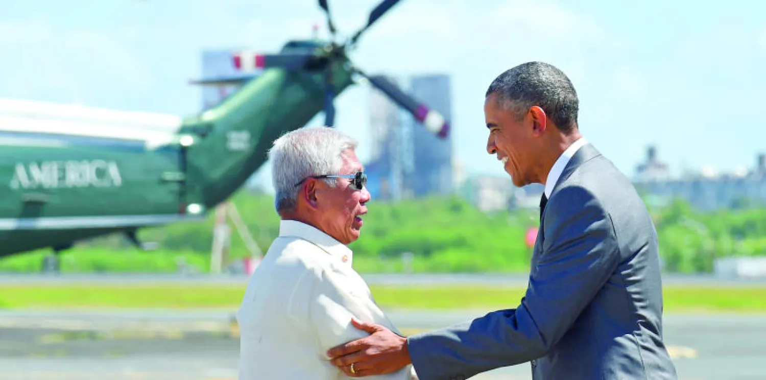 الرئيس الأميركي باراك أوباما يصافح وزير الدفاع الفلبيني فولتير غازمين لدى وصوله إلى ميناء مانيلا الدولي أمس (أ.ب)
