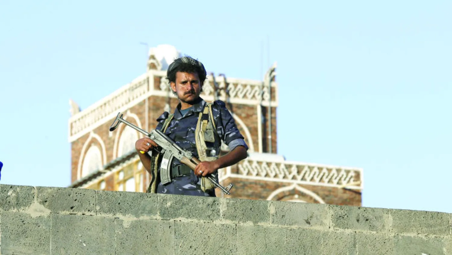 مسلح حوثي يقف حارسا على جسر بالقرب من موقع مظاهرة لجماعة  أنصار الله الحوثية ضد الضربات العسكرية للتحالف في المحافظات الخاضعة لسيطرة الانقلابيين (رويترز)