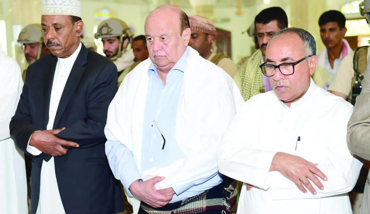 الرئيس هادي ومحافظ عدن وقيادات حكومية وعسكرية خلال تأديتهم صلاة الجمعة في عدن أمس (أ.ف.ب)