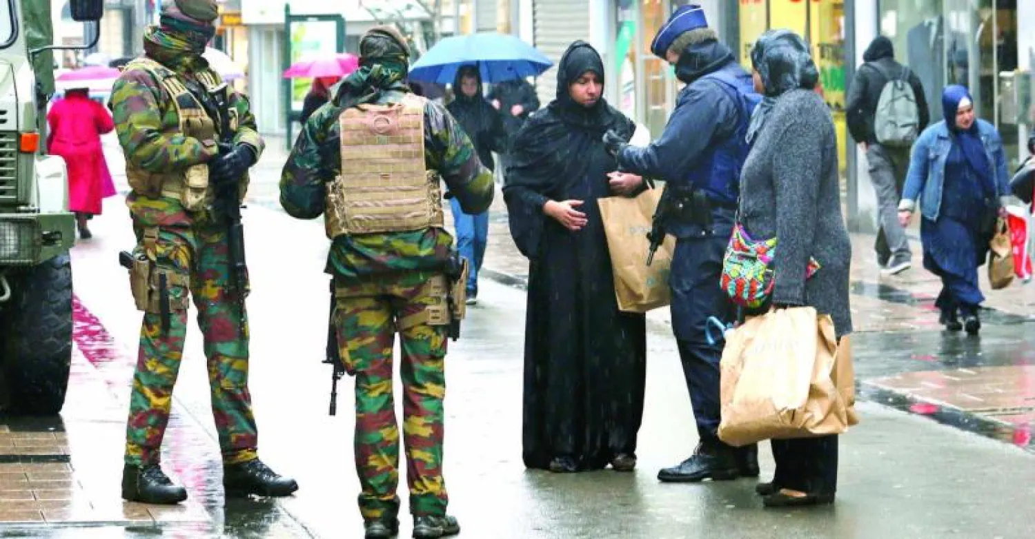 إجراءات أمنية مكثفة في شوارع بروكسل.. وفي الصورة شرطي بلجيكي يفحص وثائق هوية سيدة في الحي التجاري بوسط العاصمة أمس (أ.ف.ب)