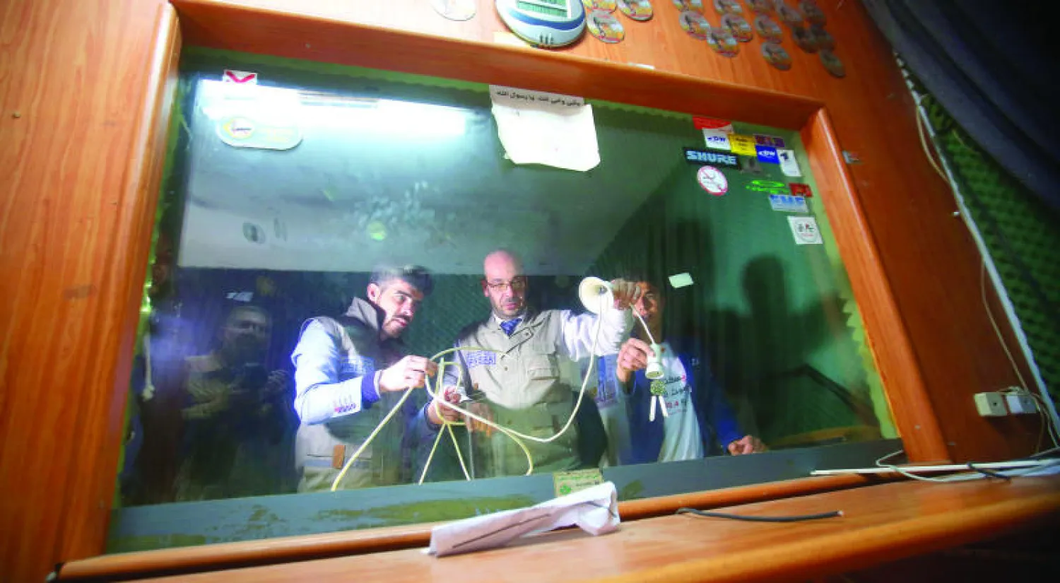 صحافيون من محطة «راديو الخليل» يعاينون الأضرار التي لحقت بالاستوديو بعد مداهمته من قبل قوات الاحتلال الإسرائيلي أمس (إ.ب.أ)