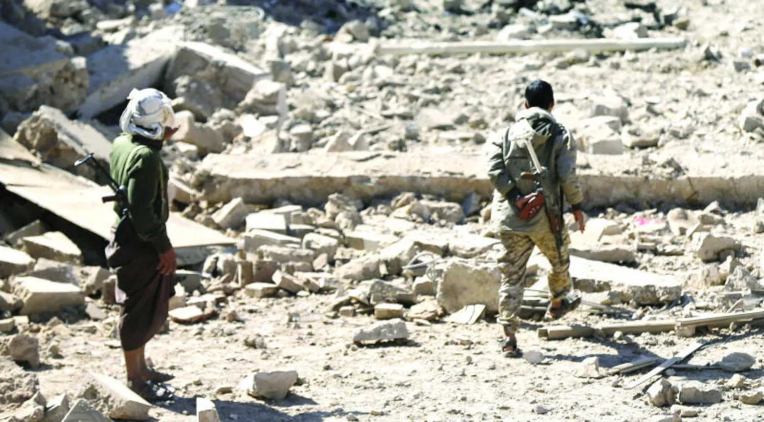 عنصران من ميليشيات الحوثيين يحرسان ساحة داخل صنعاء (رويترز)