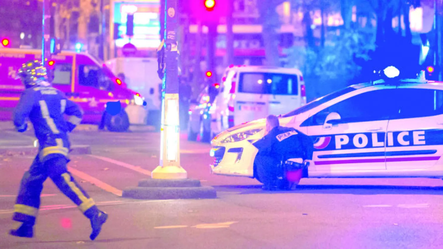 عنصران في قوات الطوارئ الفرنسية والشرطة في موقع مسرح باتاكلان في باريس الذي كان أحد مواقع هجمات باريس الجمعة قبل الماضية (أ.ب)