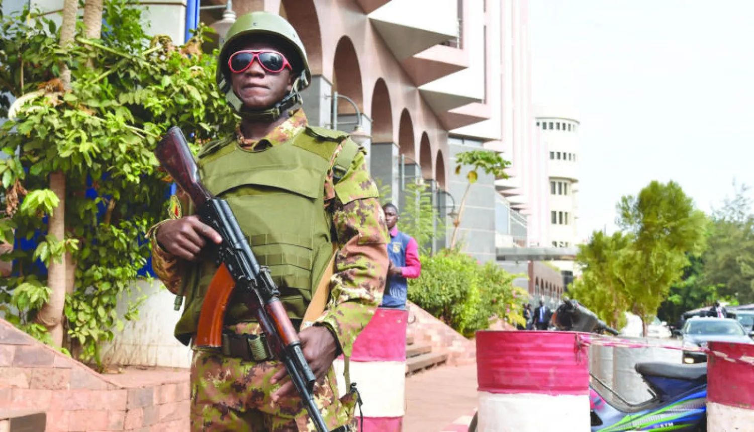 جندي مالي أمام فندق «راديسون بلو» بوسط العاصمة باماكو وسط إجراءات أمنية مشددة أمس (أ.ف.ب)