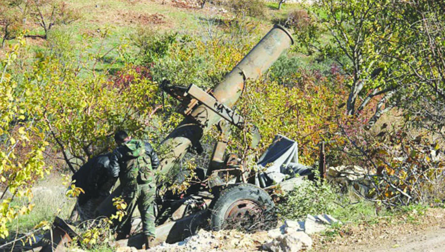 عناصر من «جيش الفتح» المعارض يجهزون لإطلاق قذيفة على قوات النظام في ريف اللاذقية (غيتي)