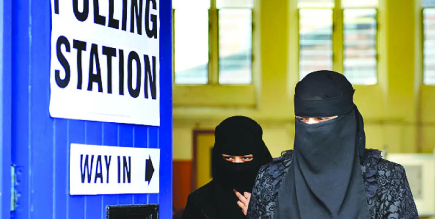 متنقبتان تغادران مكتب اقتراع في مدينة لوتن البريطانية خلال الإنتخابات التشريعية، شهر مايو (أيار) الماضي (غيتي)