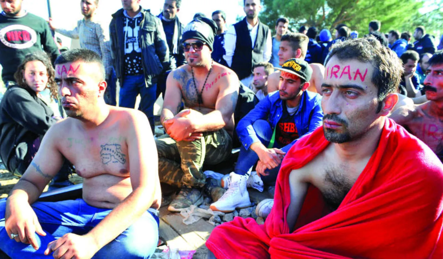 لاجئون ومهاجرون إيرانيون خيّطوا شفاههم احتجاجا على قرار صربيا ومقدونيا بالسماح للاجئين العراقيين والسوريين والأفغان فقط بعبور الحدود (أ.ف.ب)