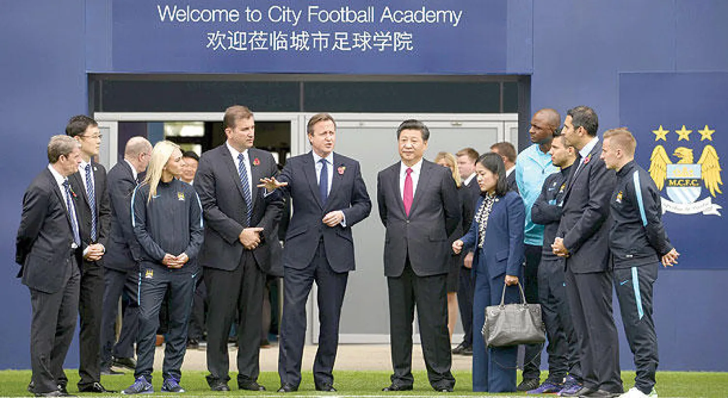 الرئيس الصيني شي جين بينغ بصحبة ديفيد كاميرون رئيس وزراء بريطانيا خلال زيارتهما لمقر مانشستر سيتي التدريبي (رويترز)