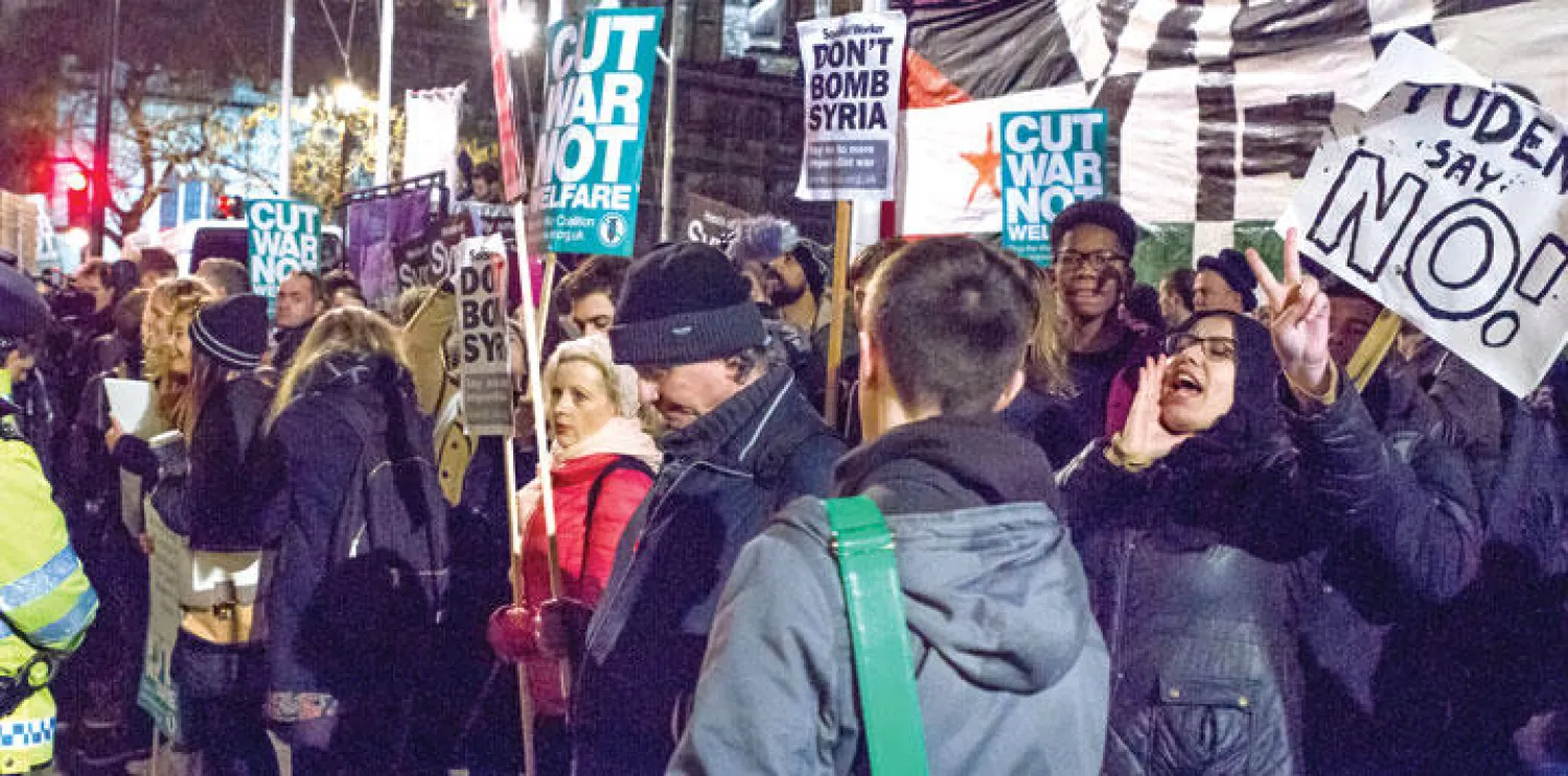متظاهرون يشاركون في وقفة احتجاجية على الضربات الجوية في سوريا أمام البرلمان البريطاني أمس (تصوير: جيمس حنا)