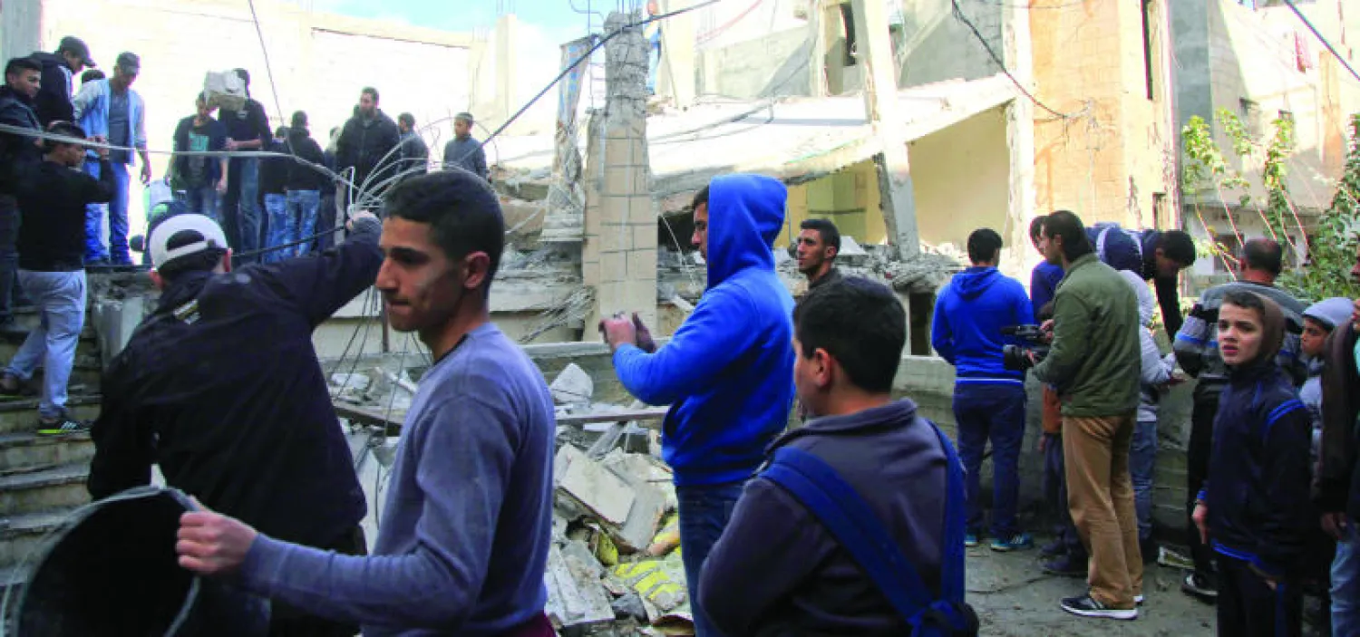 فلسطينيون يعاينون بيت إبراهيم العكري في مخيم شعفاط الذي دمرته قوات الاحتلال الإسرائيلي (أ.ب)