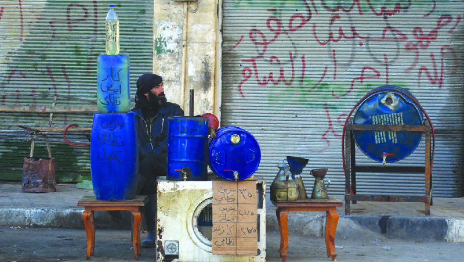 رجل من إدلب شمال غربي سوريا يبيع محروقات في الطريق العام (رويترز)