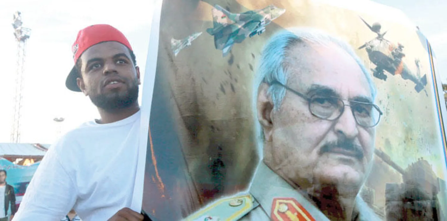 ليبي يحمل صورة للواء خليفة حفتر في مظاهرة مؤيدة للجيش الذي يقوده في مدينة بنغازي ( رويترز)