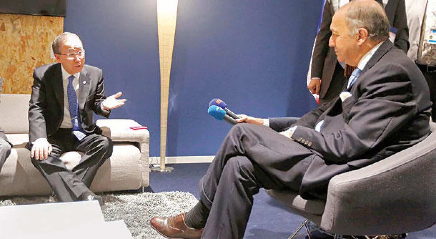 الأمين العام للأمم المتحدة بان كي مون يتحدث مع وزير الخارجية الفرنسي لوران فابيوس في اجتماع «كوب 21» أمس (رويترز)