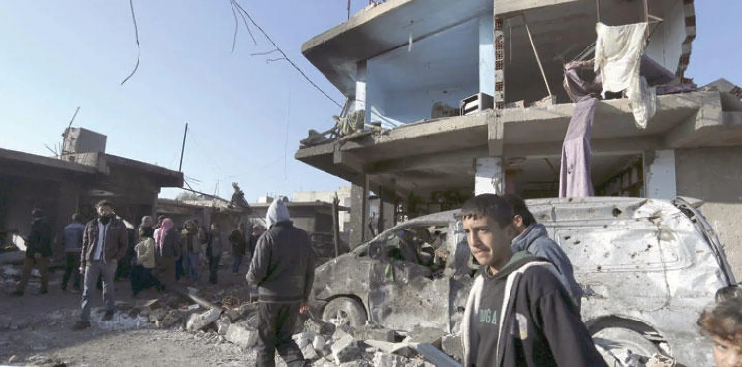 سكان بلدة تل تمر شمال شرقي سوريا يتفحصون آثار الدمار الناتج عن تفجير 3 شاحنات تابعة لـ«داعش» تسببت بمقتل 60 شخصا وجرح آخرين أمس (رويترز)