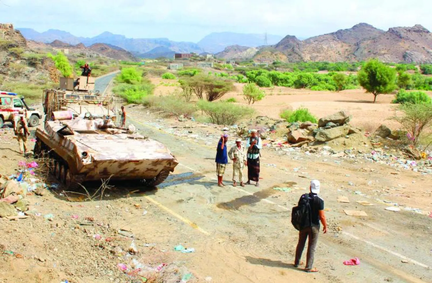 يمنيون يعاينون آثار القصف في إحدى ضواحي تعز (أ.ف.ب)