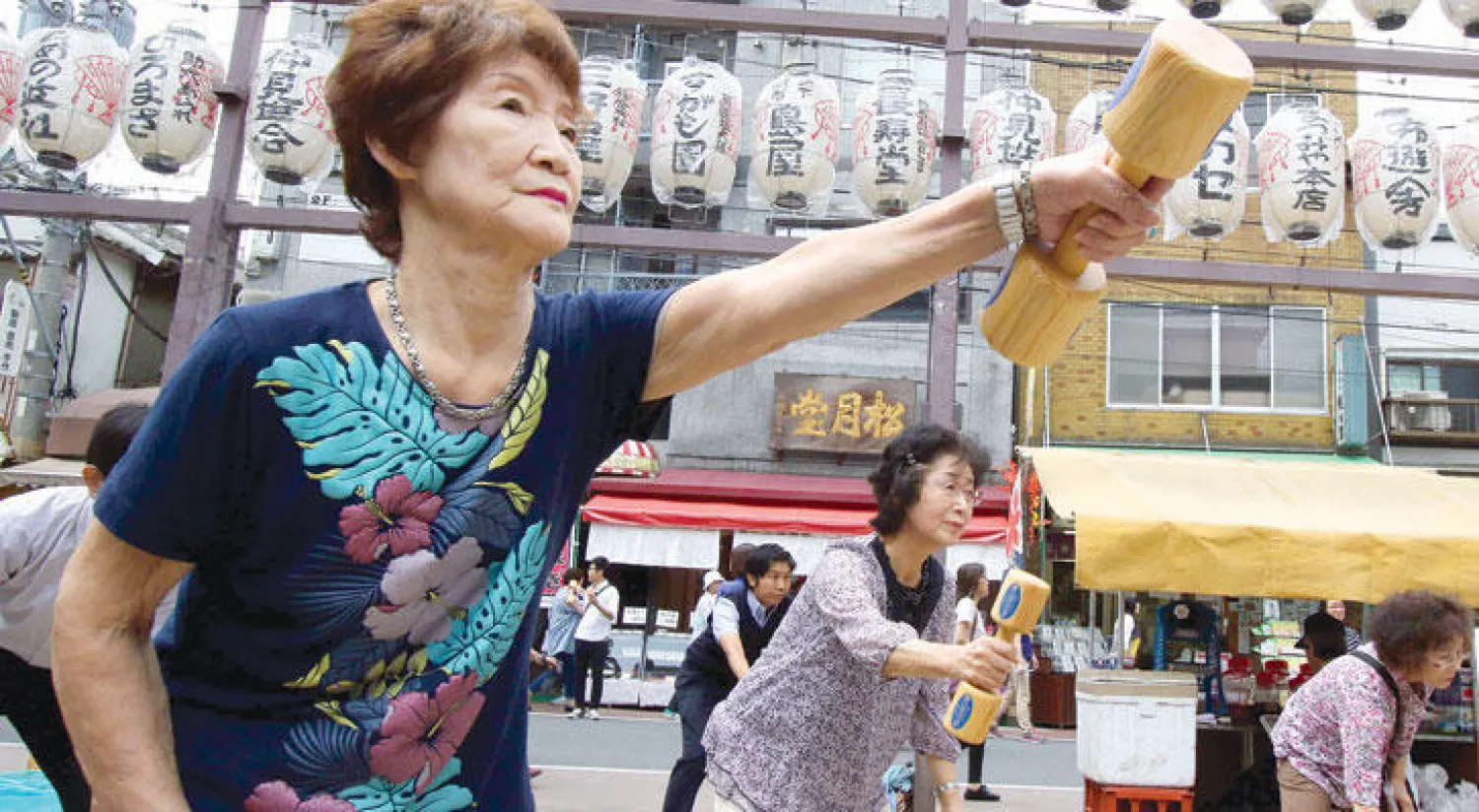 مسنون يابانيون يمارسون الرياضة اليومية في ساحة معبد في طوكيو (أ.ف.ب)