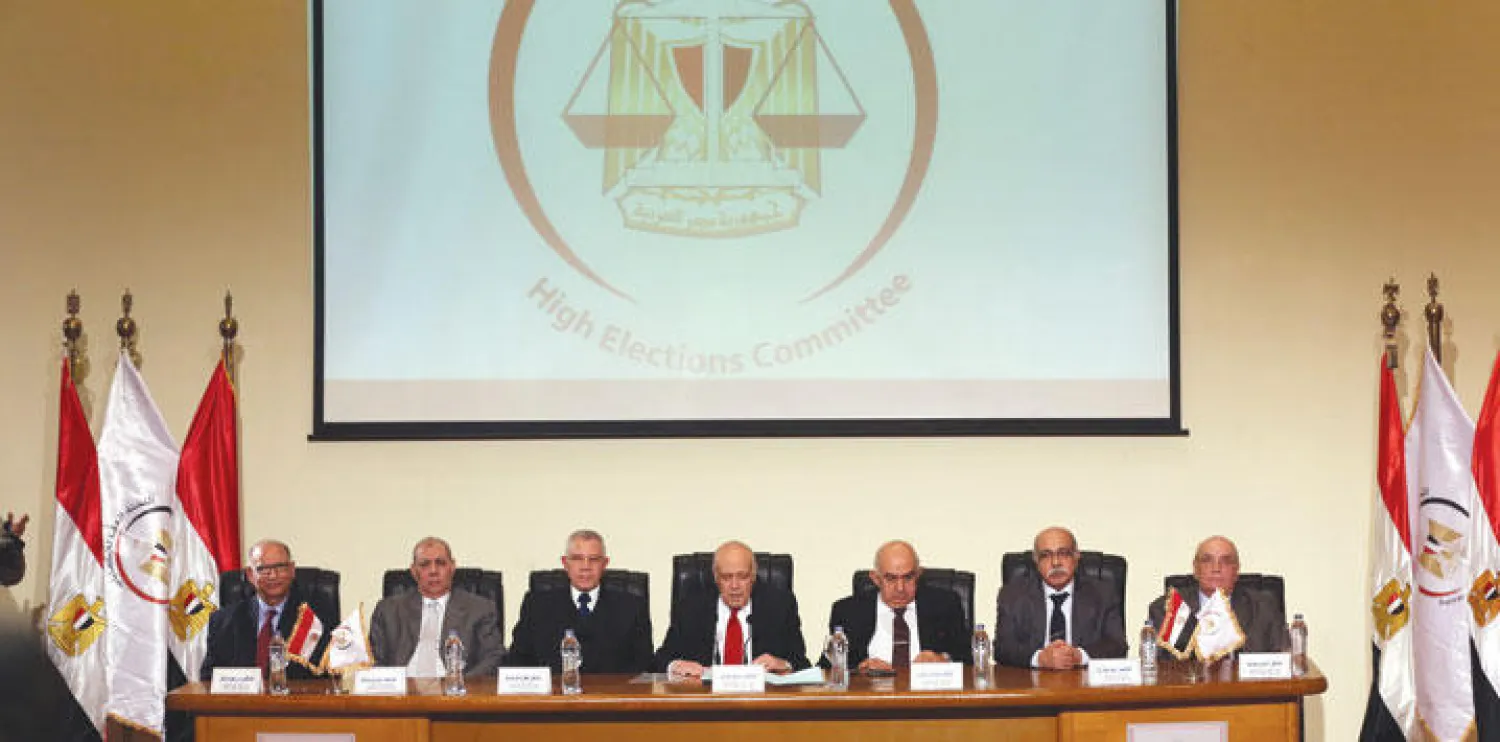 صورة أرشيفية لرئيس اللجنة العليا للانتخابات أيمن عباس (وسط) أثناء المؤتمر الصحافي الذي أعلن خلاله النتائج النهائية للانتخابات البرلمانية (إ.ب.أ)