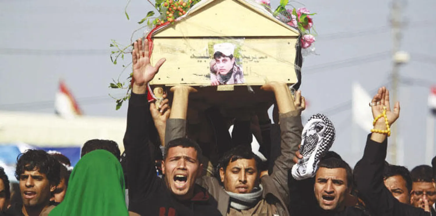 عراقيون يحملون أمس نعش أحد الجنود العراقيين الذين قتلوا بسبب قصف طائرات التحالف بالخطأ قرب الفلوجة (أ.ف.ب)