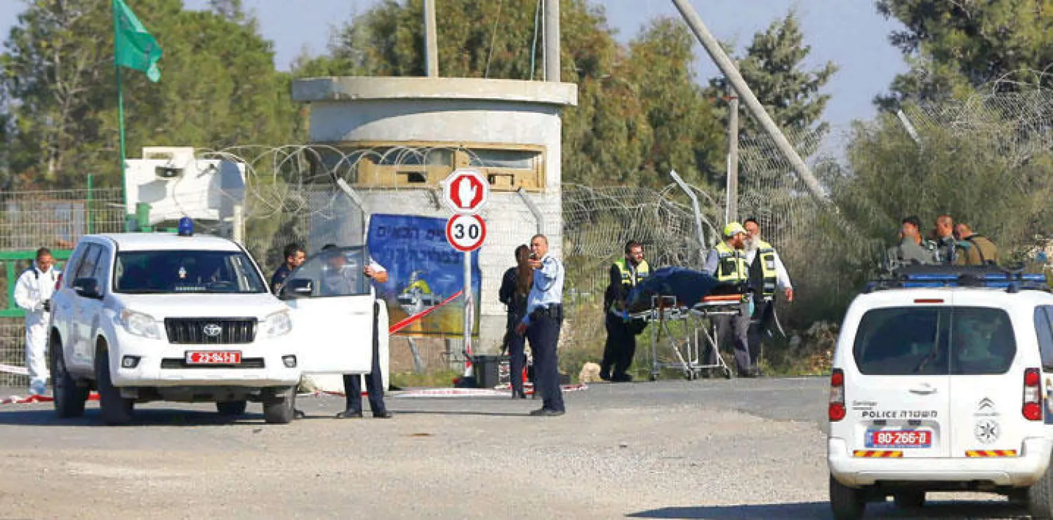 جنود الاحتلال يقومون بحراسة يهود يجلون جثة الفلسطيني الذي قتل بعد محاولته دهس مجموعة من الجنود الإسرائيليين (أ.ف.ب)