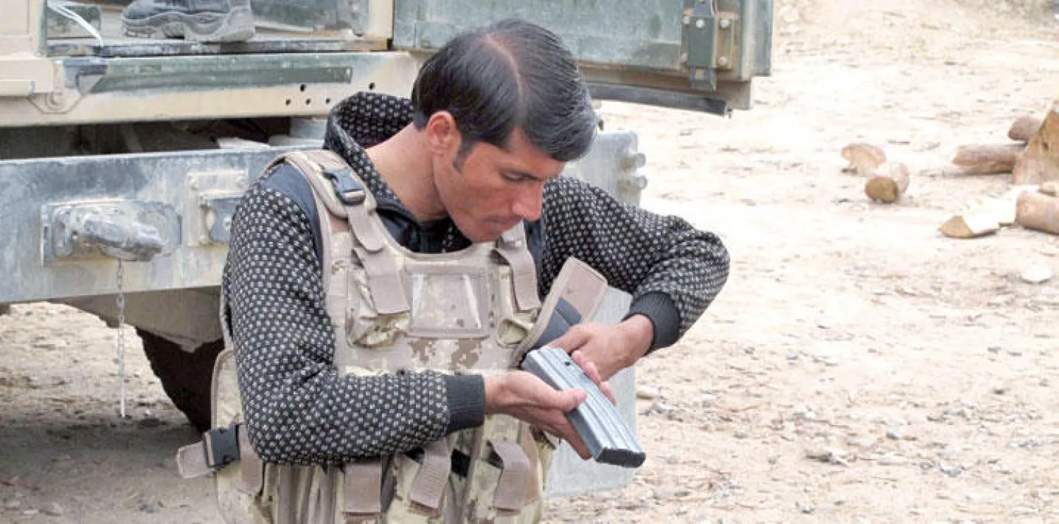 جندي في قوات الامن الافغانية يعد سلاحه قبل انطلاق عملية ضد مقاتلي طالبان في اقليم هلمند أمس (إ.ب.أ)