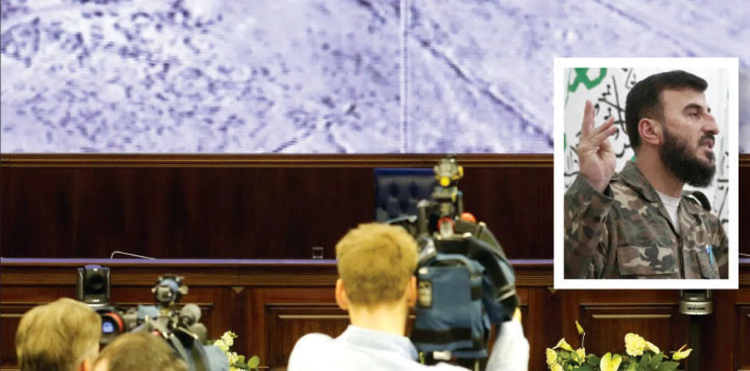 صحافيون يتابعون في مقر وزارة الدفاع الروسية بموسكو ضربات القاذفات الروسية على مواقع سورية أمس وفي الاطار زهران علوش قائد {جيش الإسلام} الذي قتل في غارة روسية قرب دمشق أمس (رويترز)