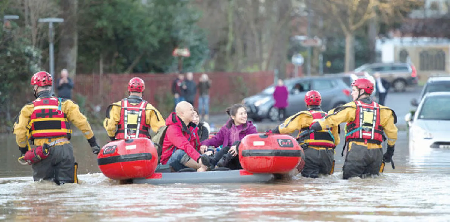 فرق الإنقاذ تجلي سكانا من أحياء غمرتها مياه الفيضانات في مدينة يورك بشمال إنجلترا أمس (أ.ف.ب)