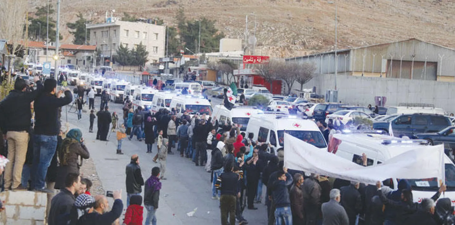 قافلة من سيارات الإسعاف تحمل مسلحين ومصابين من منطقة الزبداني المحاصرة إلى نقطة المصنع على الحدود اللبنانية السورية (رويترز)