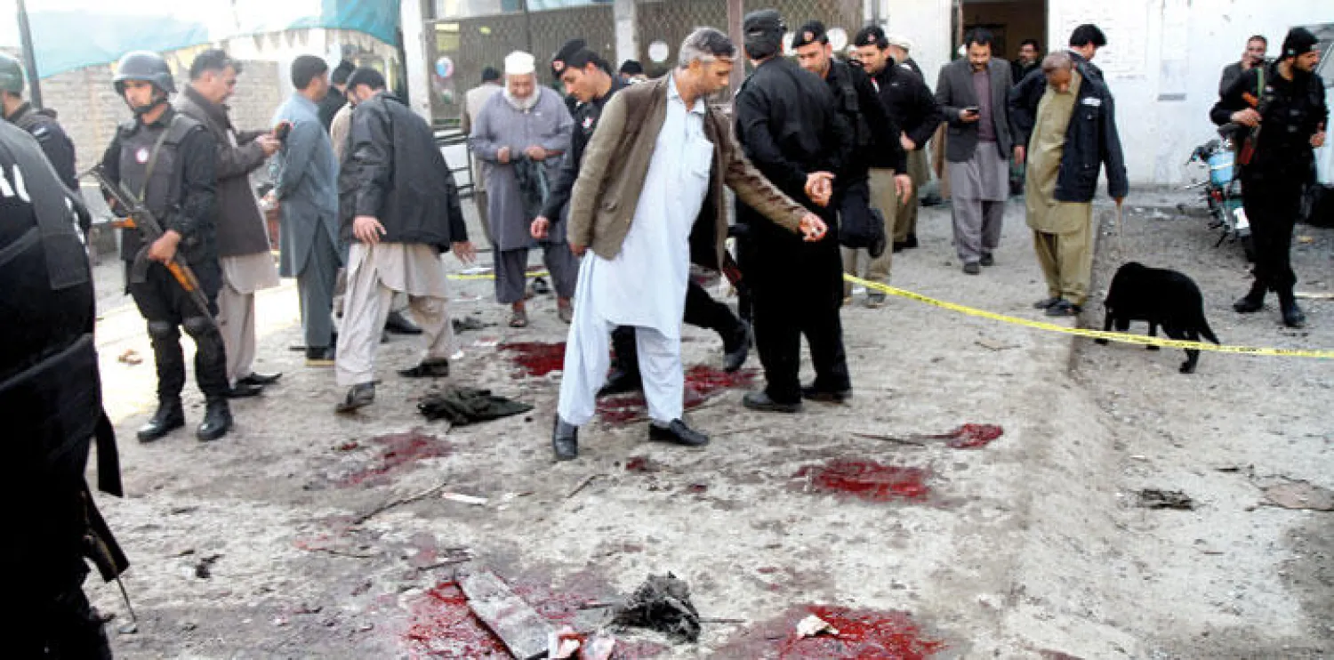 موقع التفجير الانتحاري في بلدة ماردان أمس أمام مدخل إدارة حكومية في شمال غربي باكستان  (أ.ب)