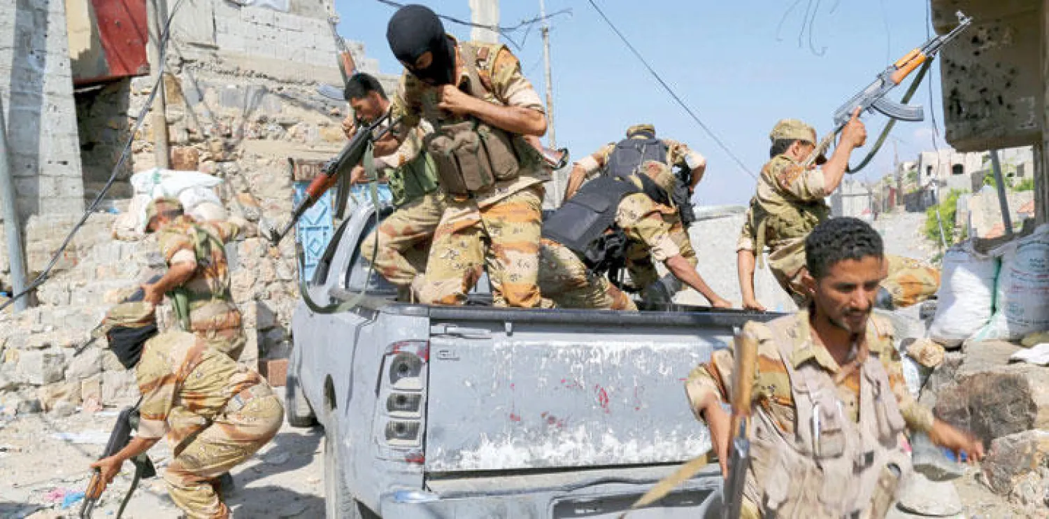 جنود يمنيون موالون للشرعية يقفزون من عربة عسكرية أثناء عملية تدريب في مدينة تعز (رويترز)
