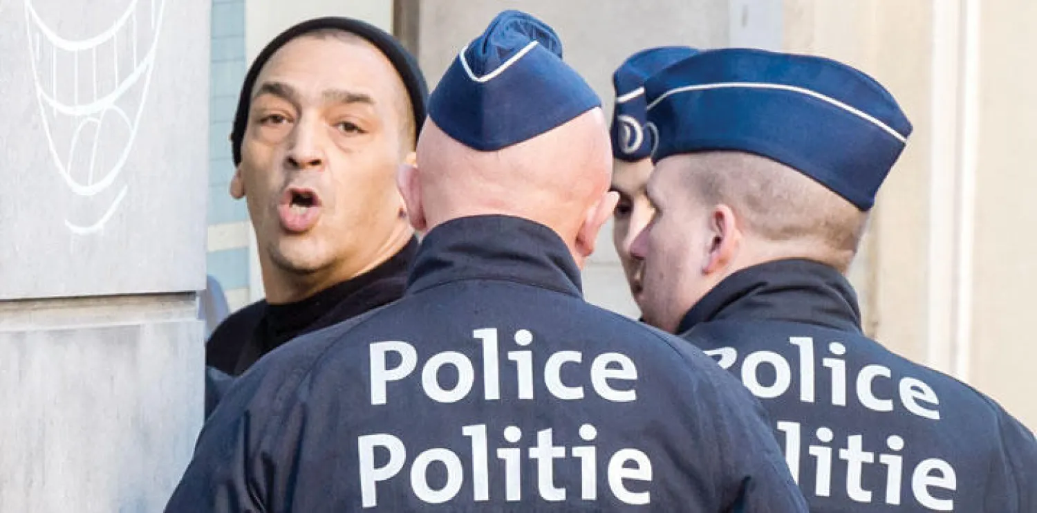 ضابطا شرطة بلجيكيان يعتقلان شخصًا في وسط العاصمة بروكسل أمس ضمن الإجراءات الأمنية على خلفية هجمات باريس في نوفمبر الماضي (أ.ب)