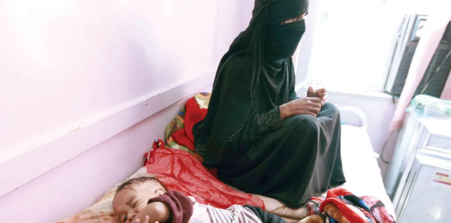 يمنية تجلس بجانب طفلها الذي يعاني سوء التغذية في أحد المراكز الصحية بصنعاء (أ.ف.ب)