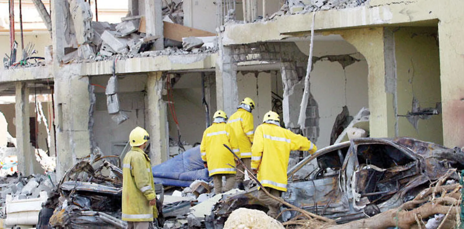 رجال الدفاع المدني السعودي يعاينون أحد المباني التي تعرضت لعملية إرهابية في الرياض ({الشرق الأوسط})